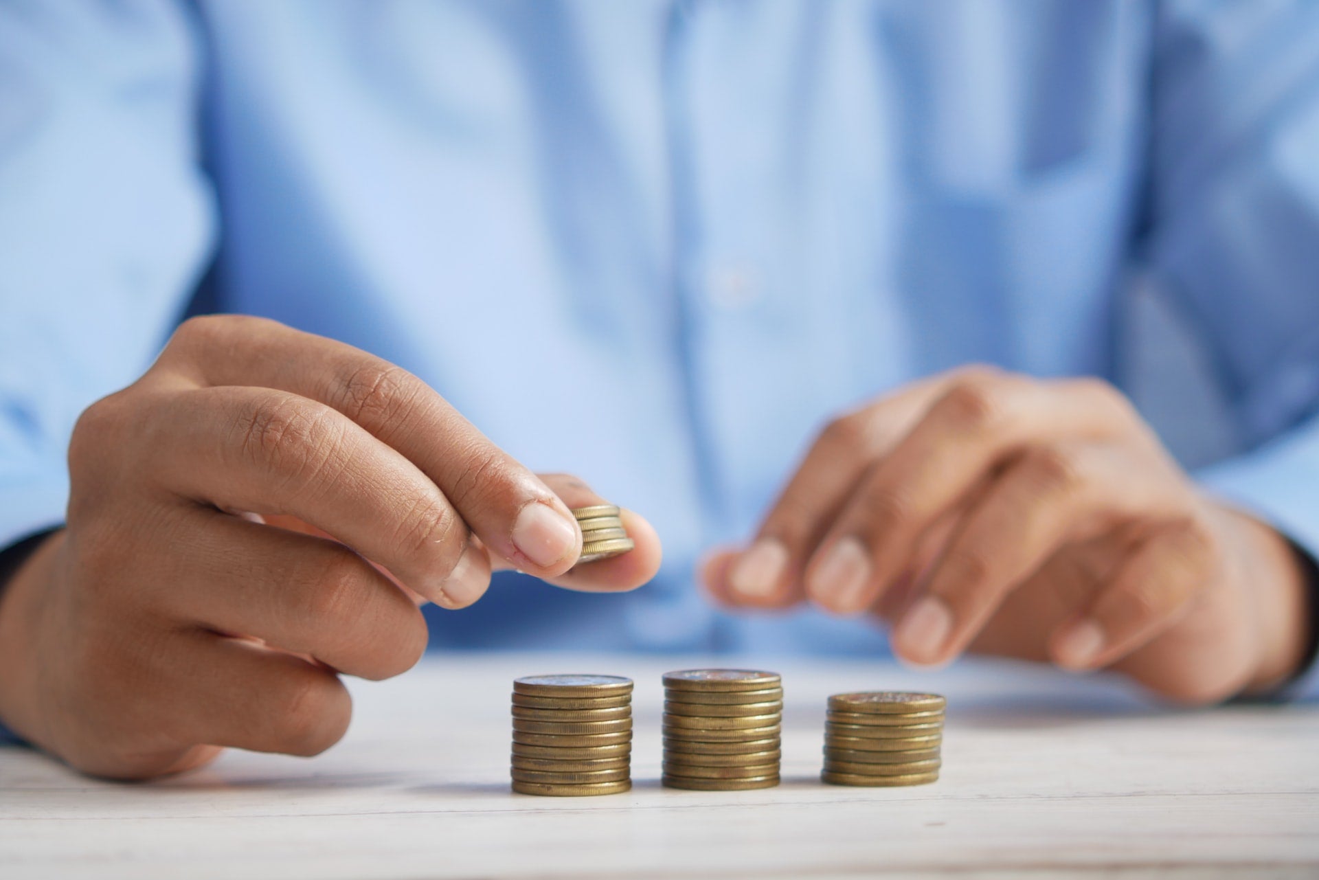 hands counting coins to represent registering for taxes