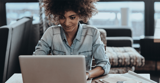 WordPress designer works at a laptop at her home desk