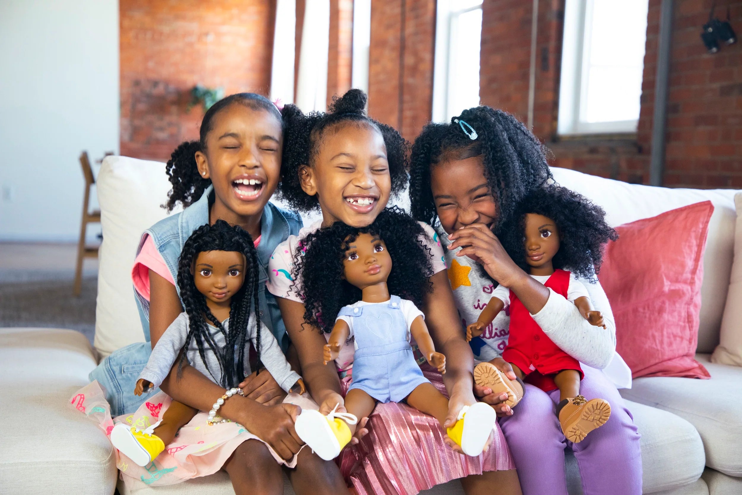 Three young girls hold Healthy Roots dolls