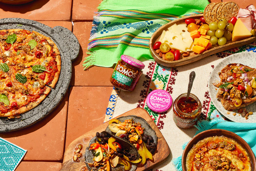 A spread of food featuring jars of Somos condiments