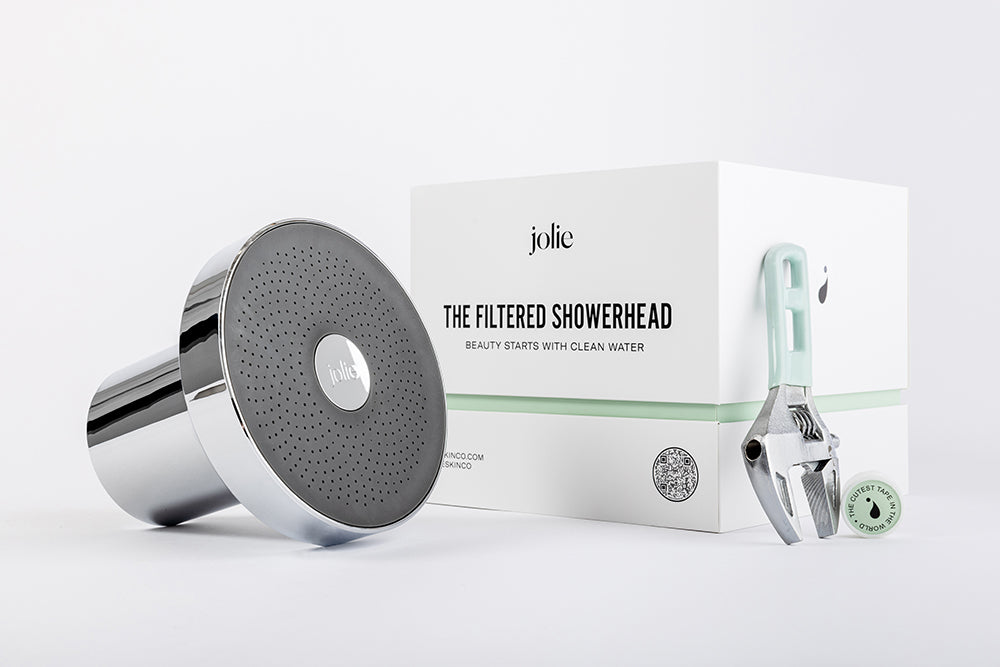 A Jolie showerhead next to its packaging and a wrench