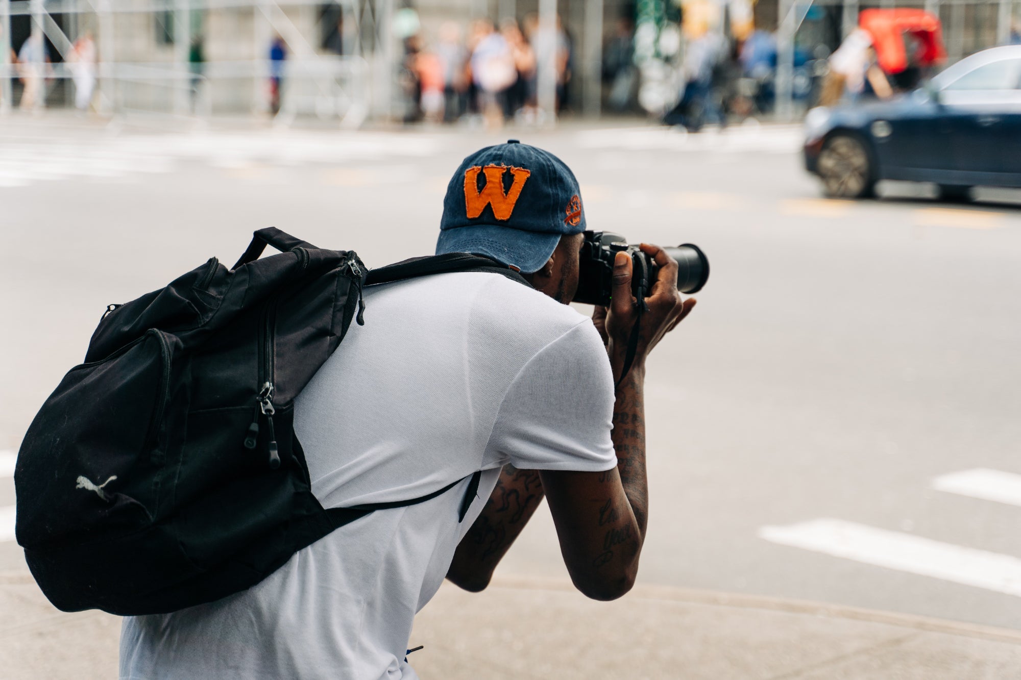 A young person photographs a city street
