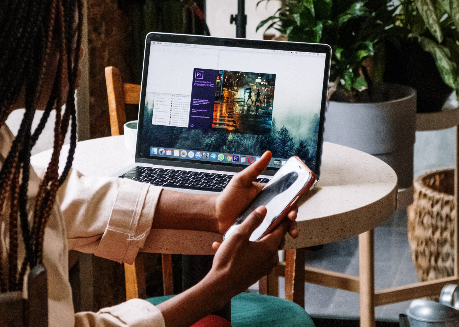 A woman sits at a laptop in a cafe setting