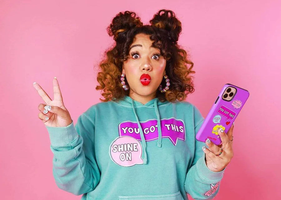 ColorMeCourtney poses in merch she produced for her personal brand