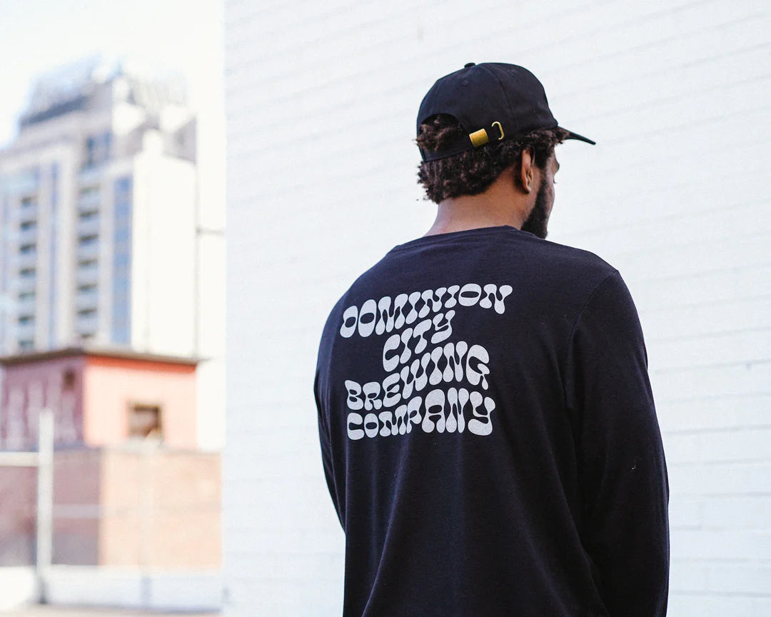 Person with back to the camera wears a branded shirt from a brewery