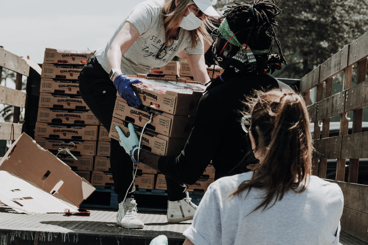 Two people unload donations from a truck