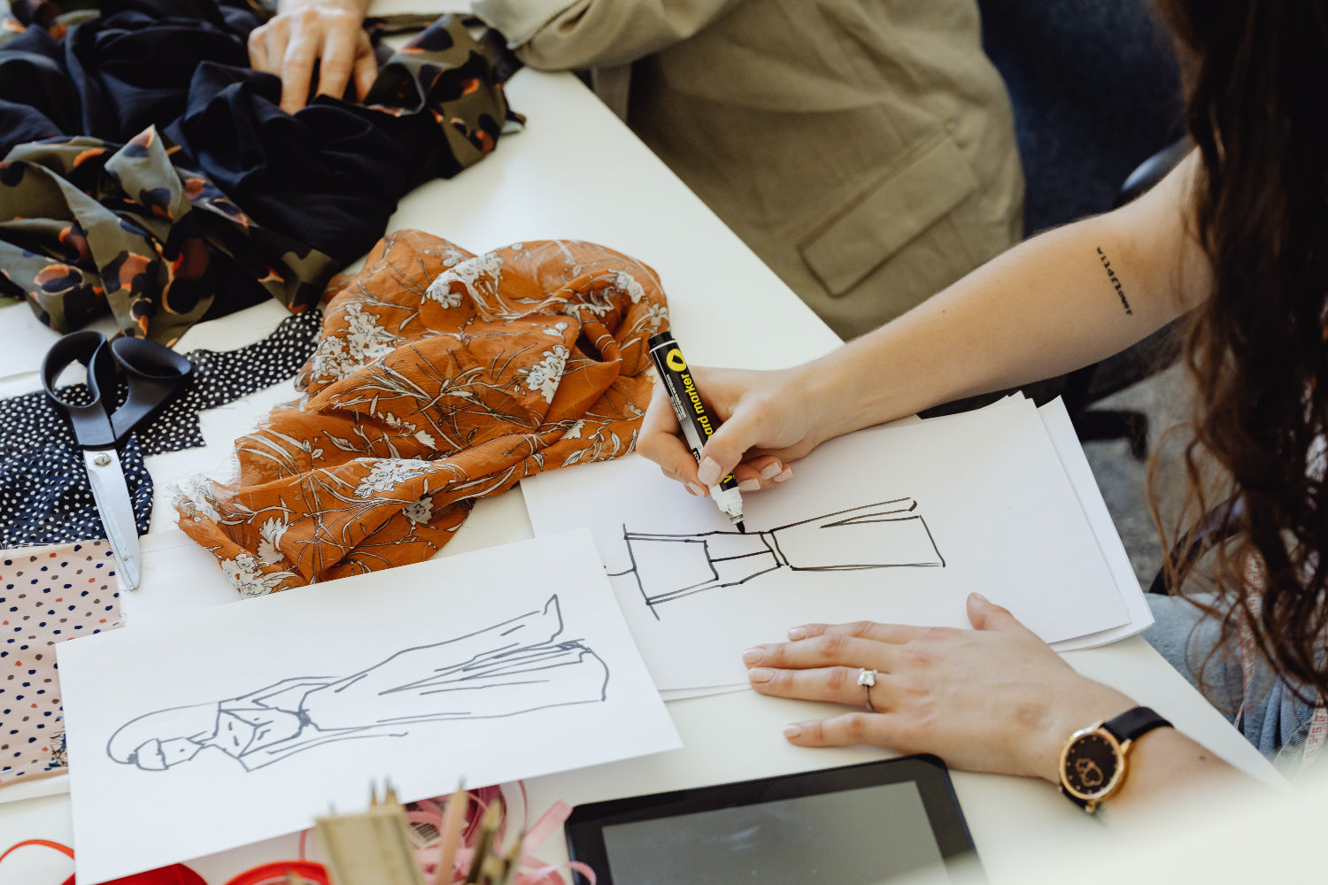 A fashion designer sketches some clothing ideas