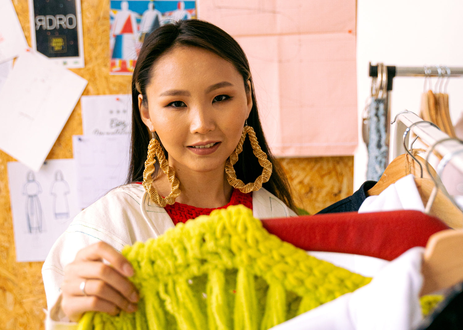 A woman peruses a clothing rack in a design studio