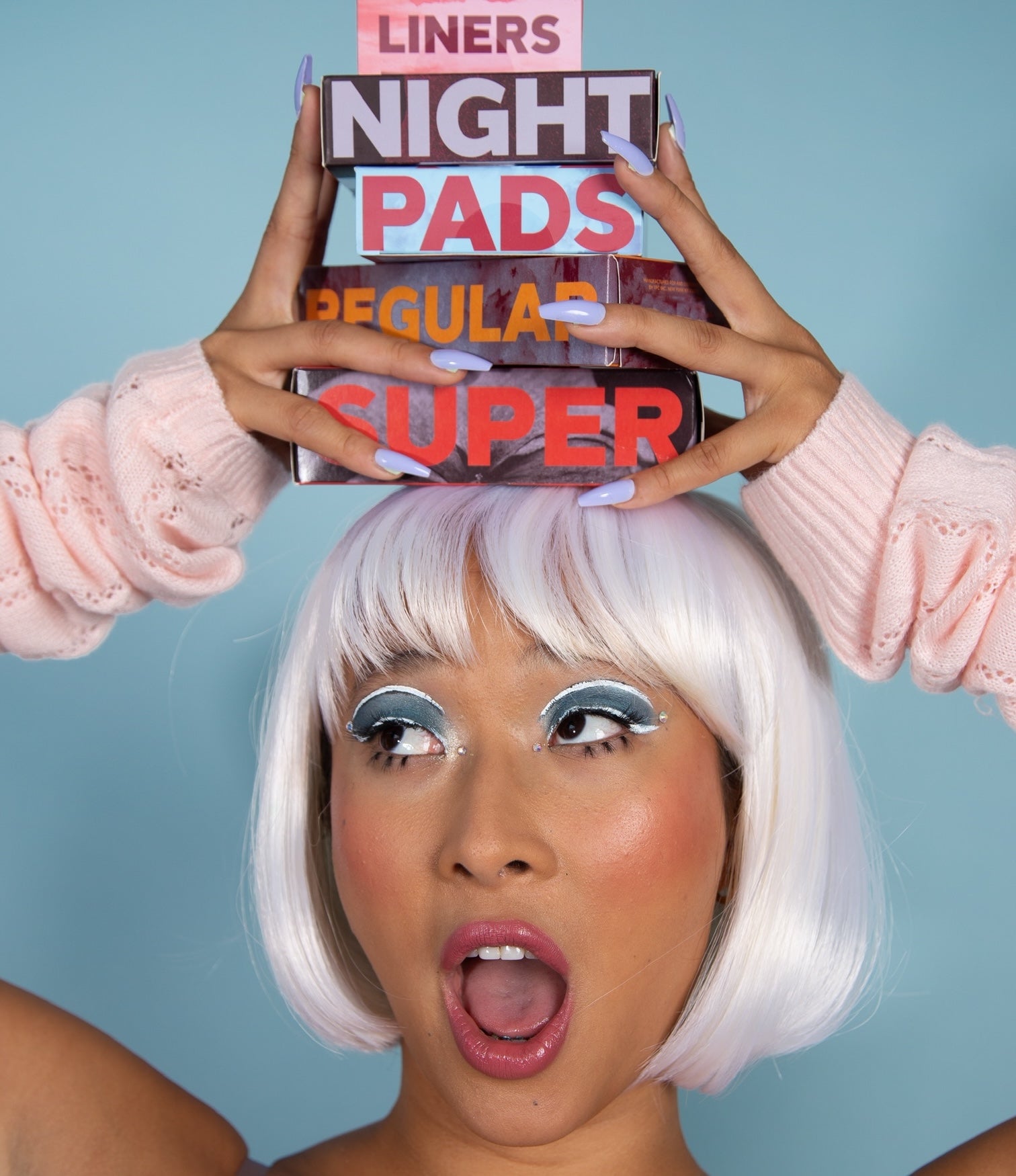 Nadya Okamoto holds boxes of august products on her head.