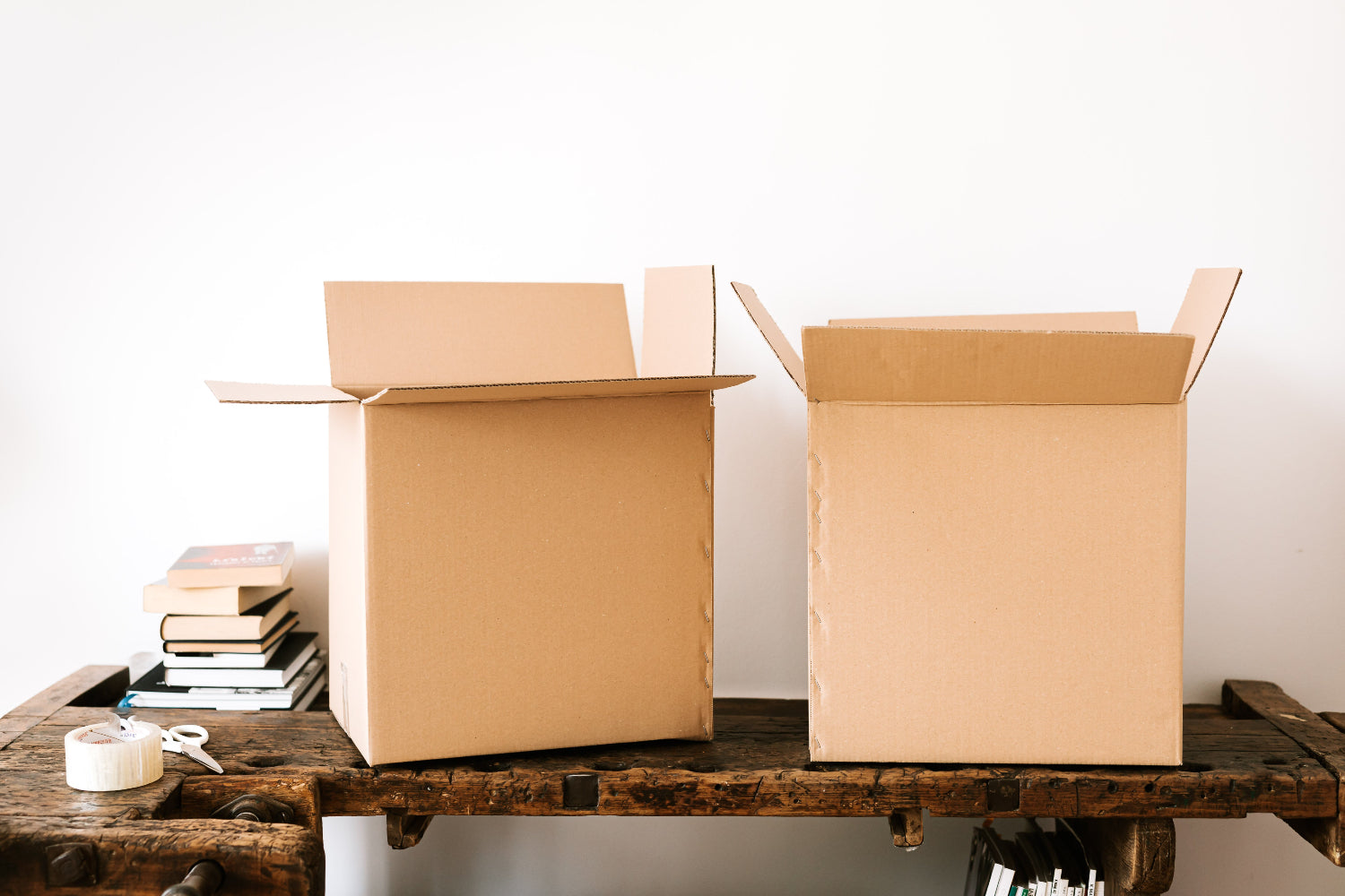 Two cardboard boxes open on a table ready to be packed for an online business