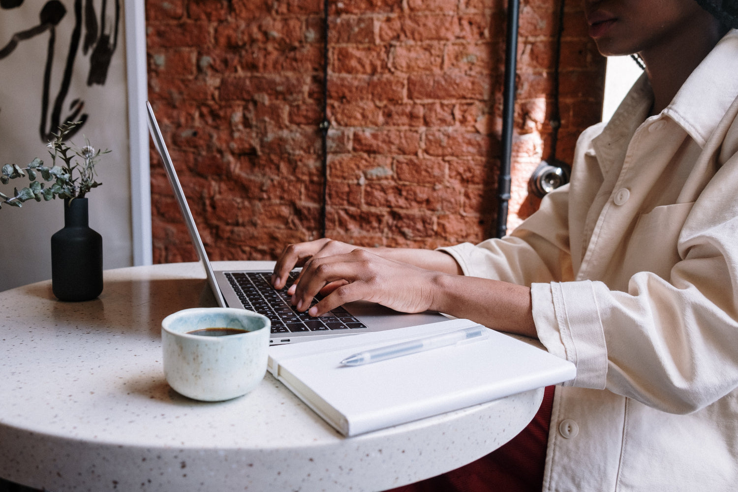 A person types on a laptop while making money at home