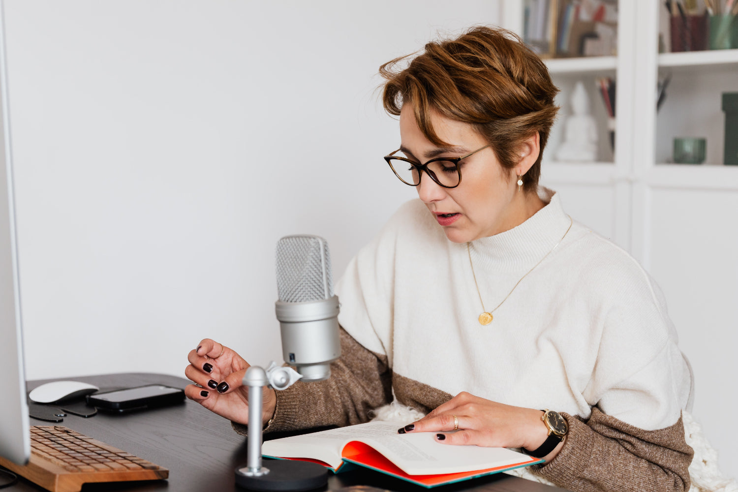 A woman makes money at home narrating a book using a professional microphone