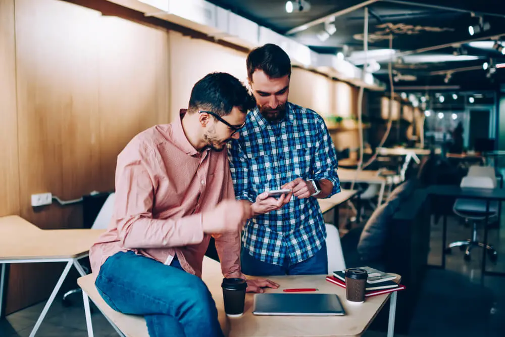 Two people researching how to write survey questions.