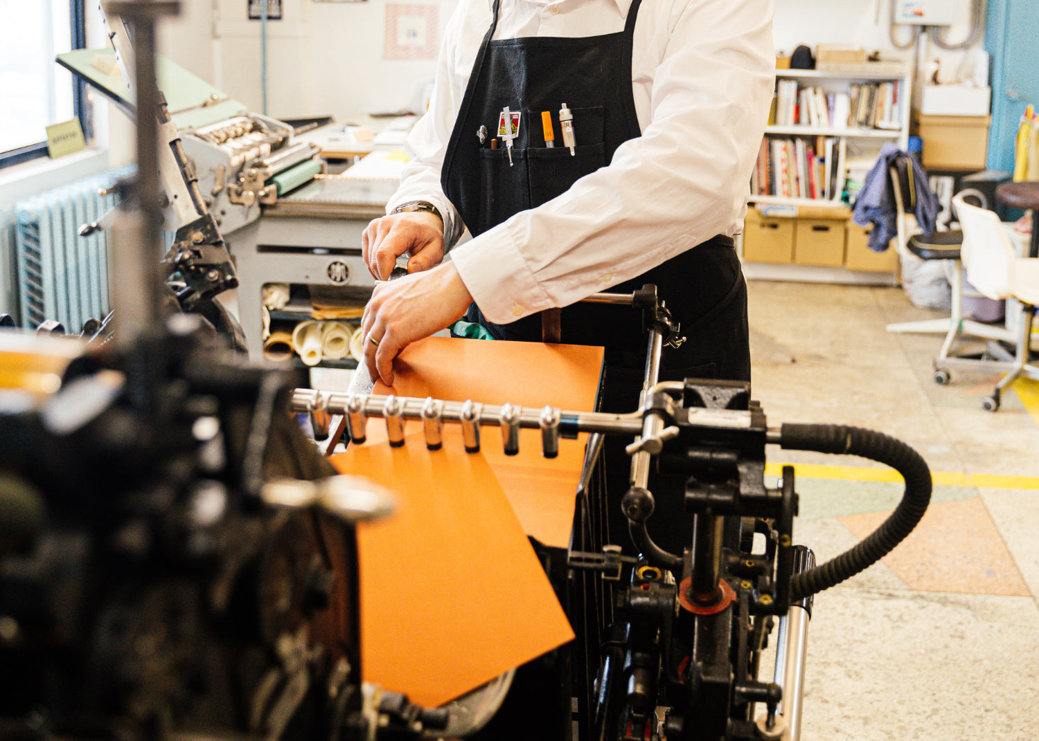 A person operates a commercial printer