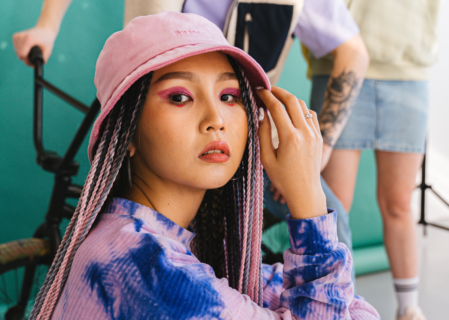 Young woman in skater gear wearing a pink bucket hat