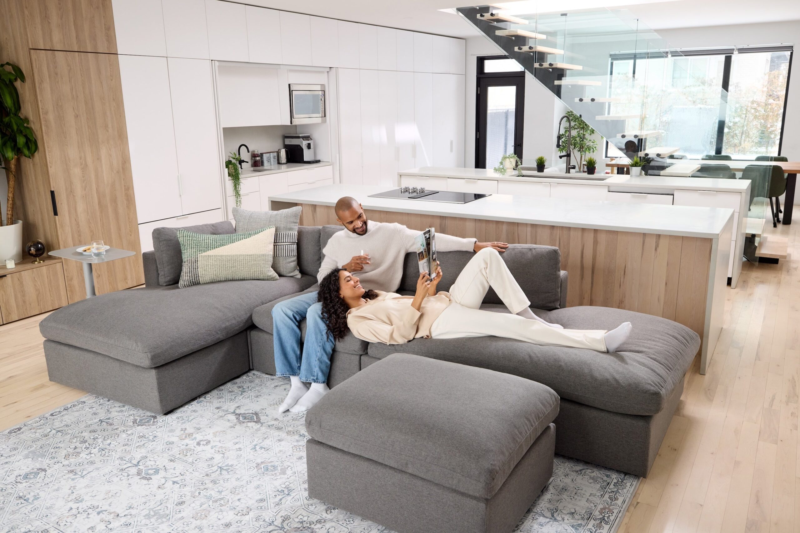 A male/female couple lounging on Cozey couches in a modern, light-filled, loft space.