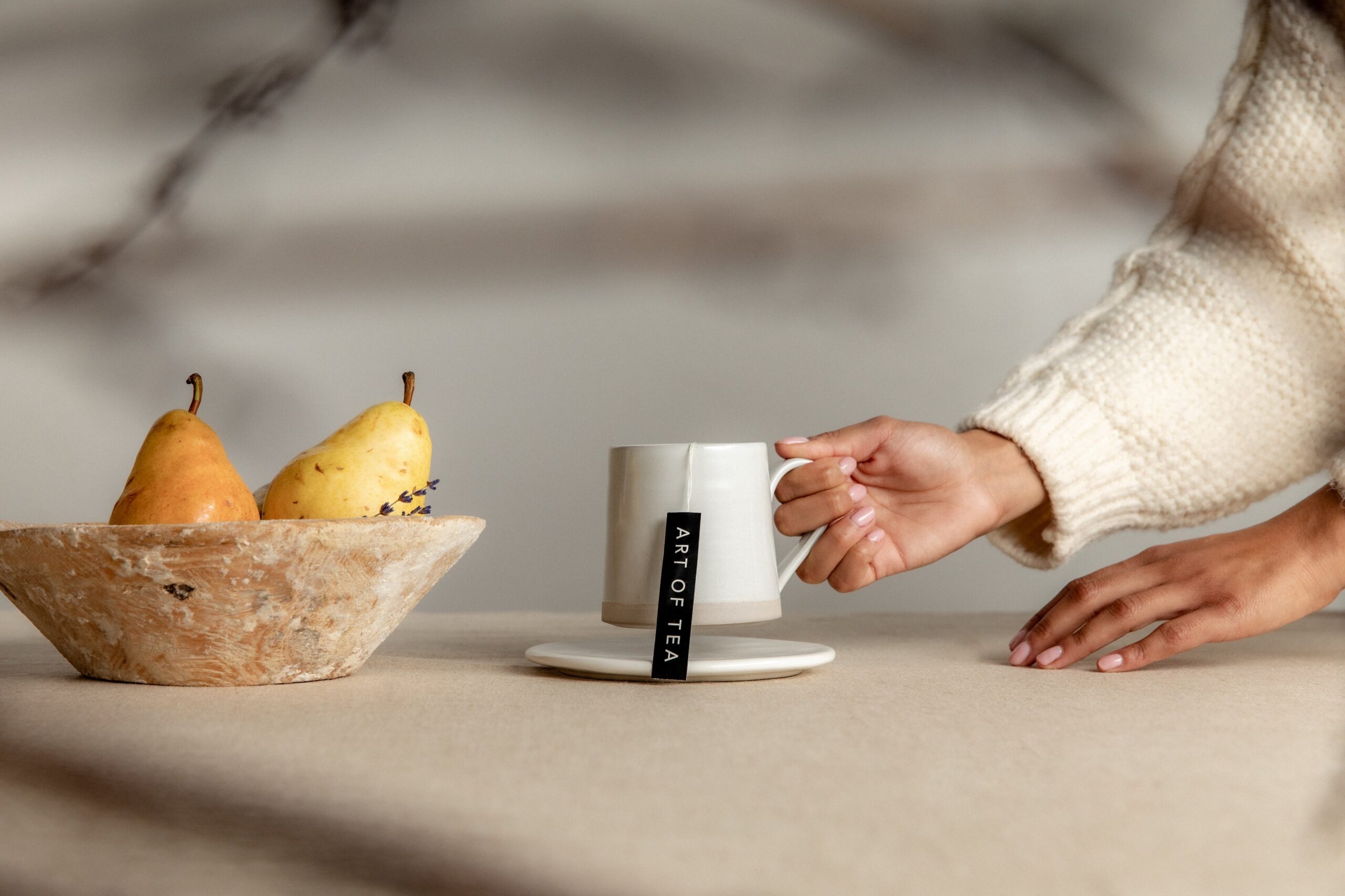 a hand holds a mug with an art of tea blend.