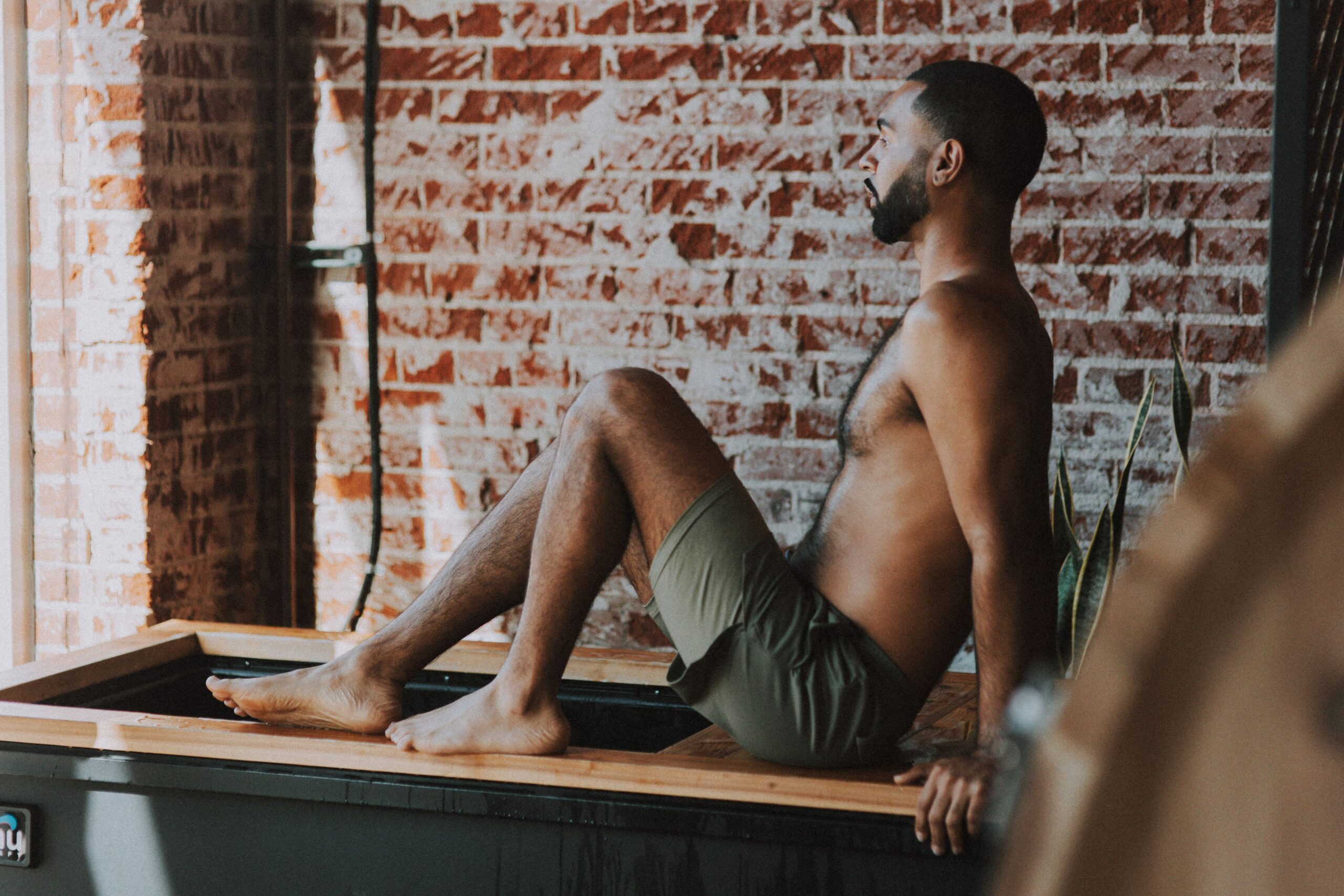 a person rests on the breath deck of a Renu therapy cold plunge tank.