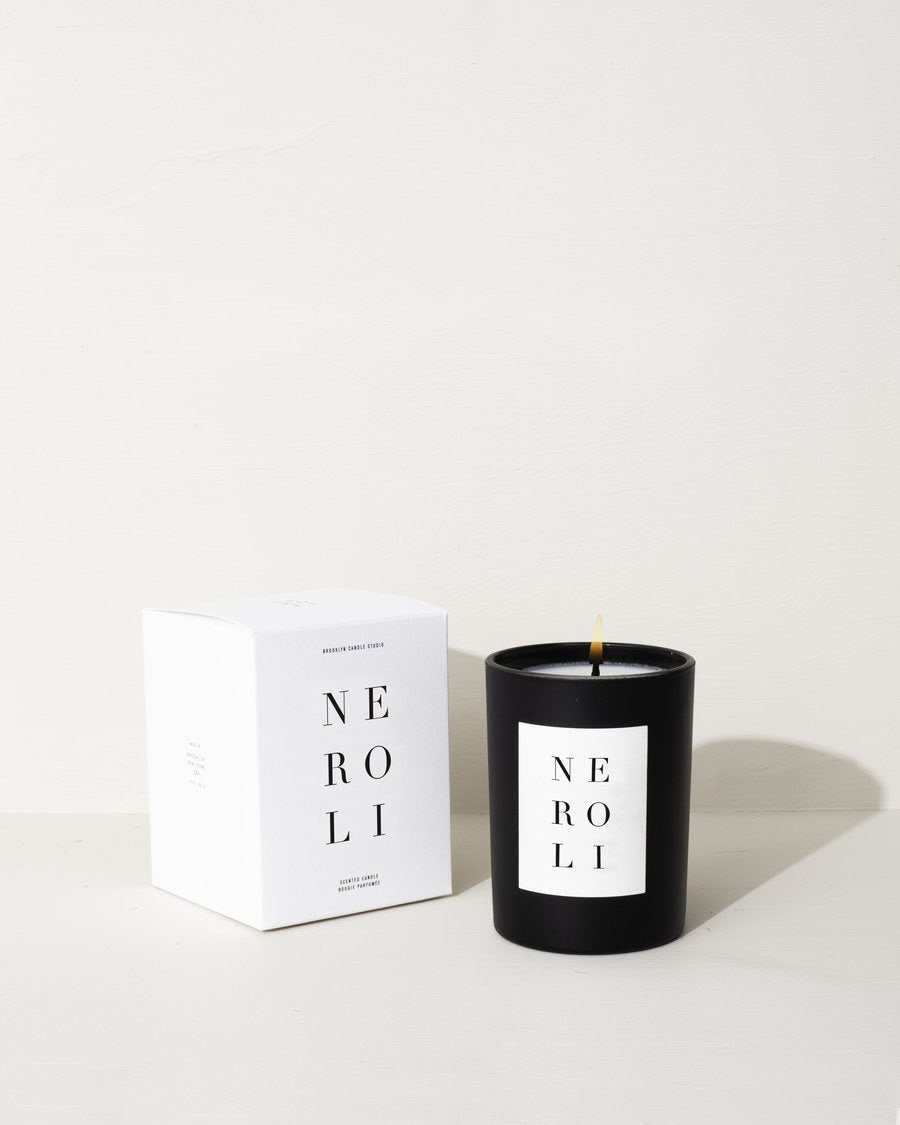 A Neroli-scented candle next to its elegant box from vegan candle business Brooklyn Candle Studio