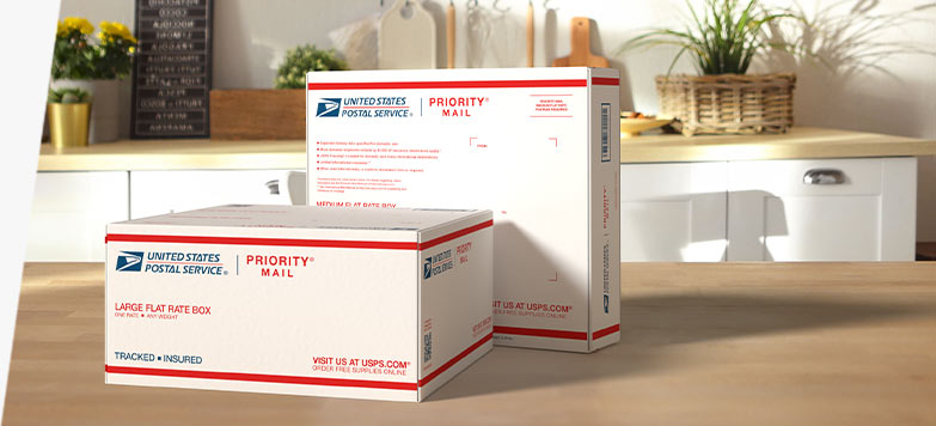 Photo of two USPS Priority Mail shipping boxes on a wooden counter.