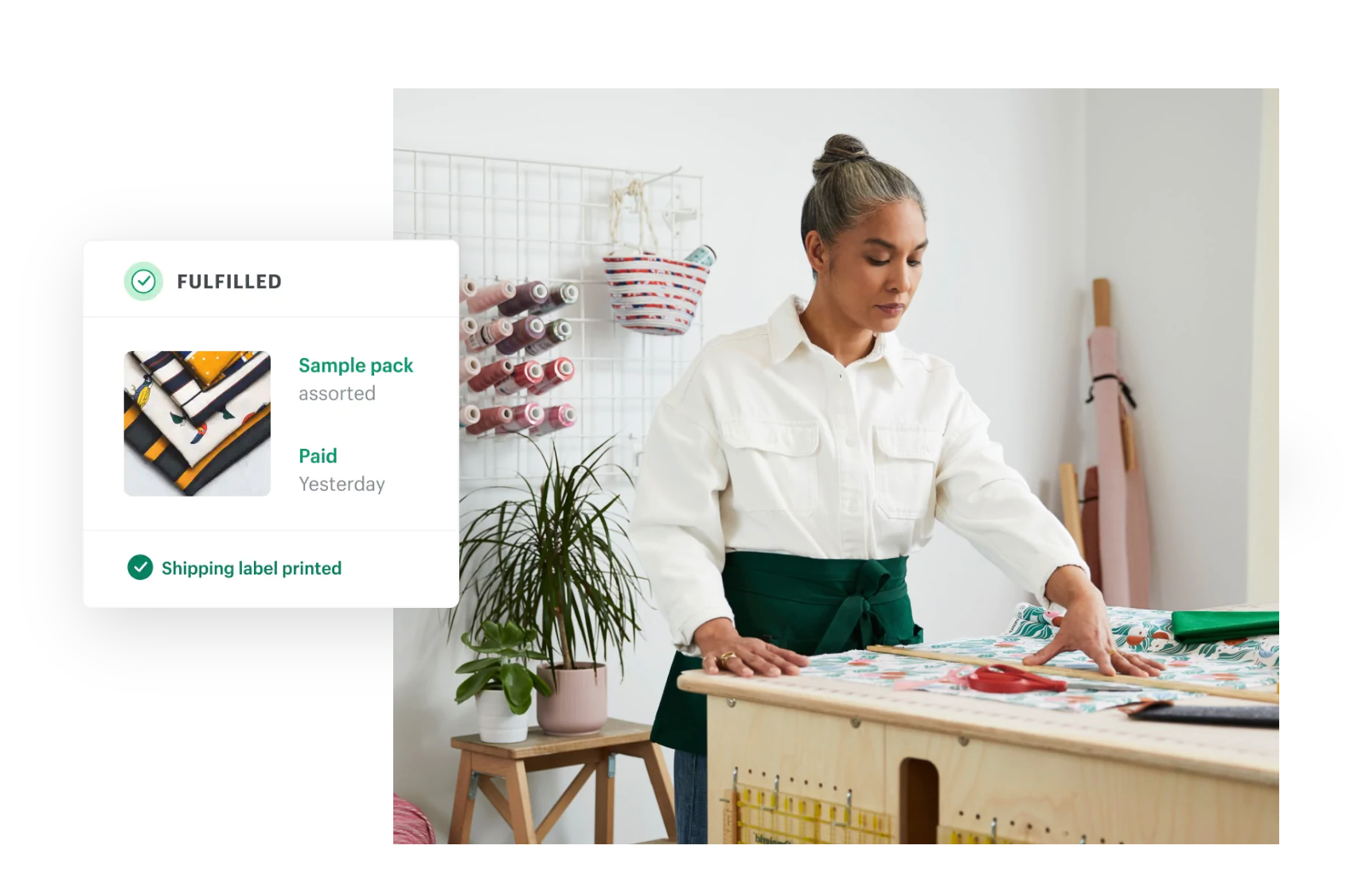 Image of a person with materials on a worktable with a “fulfilled” message in the Shopify admin.