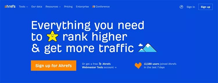 Screenshot of the Ahrefs homepage with the text: 'Everything you need to rank higher & get more traffic'. Includes sign-up button and user statistics.