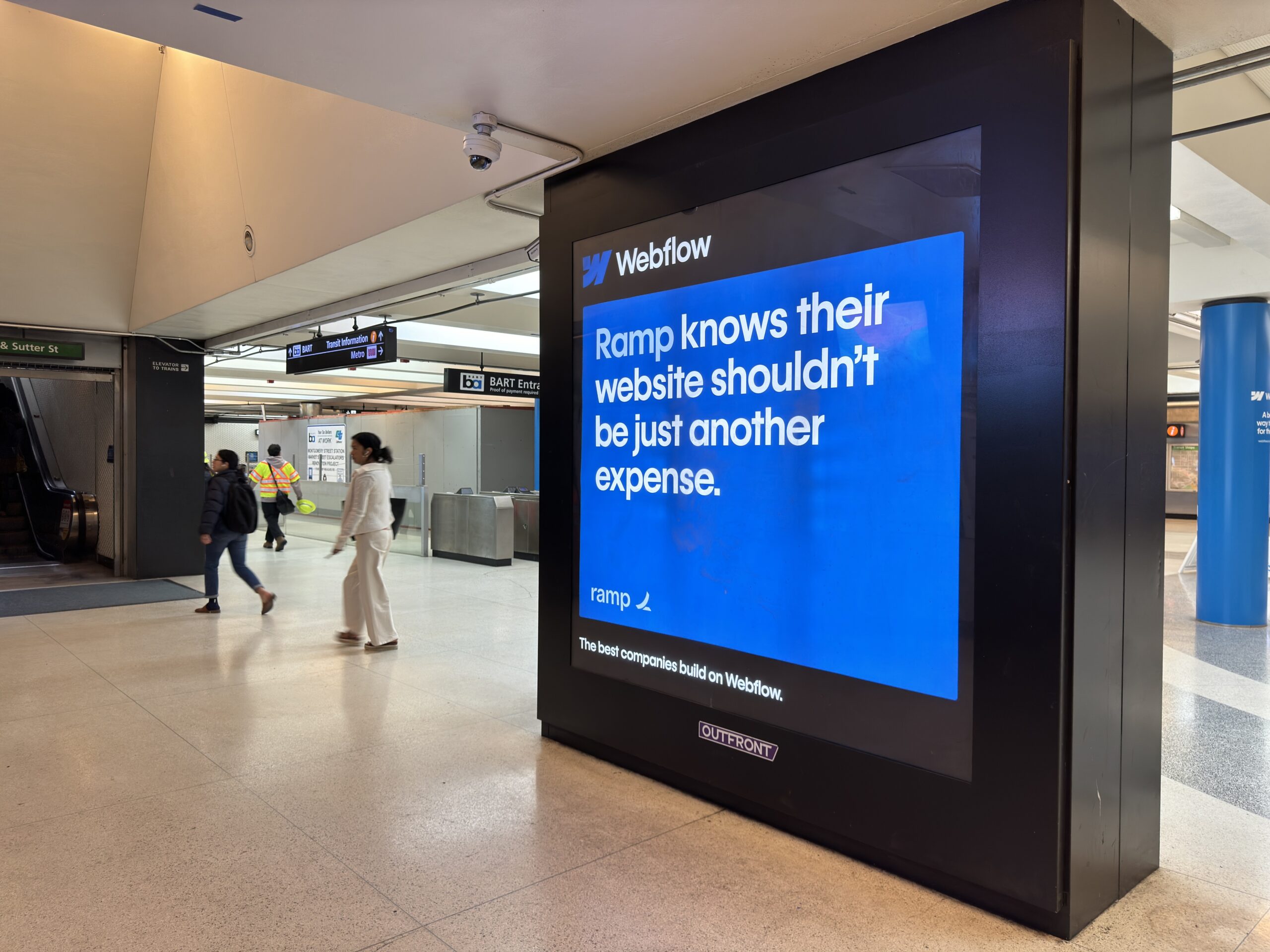 A phtoto of a large digital display in the BART station in San Francisco displaying an ad for Webflow.