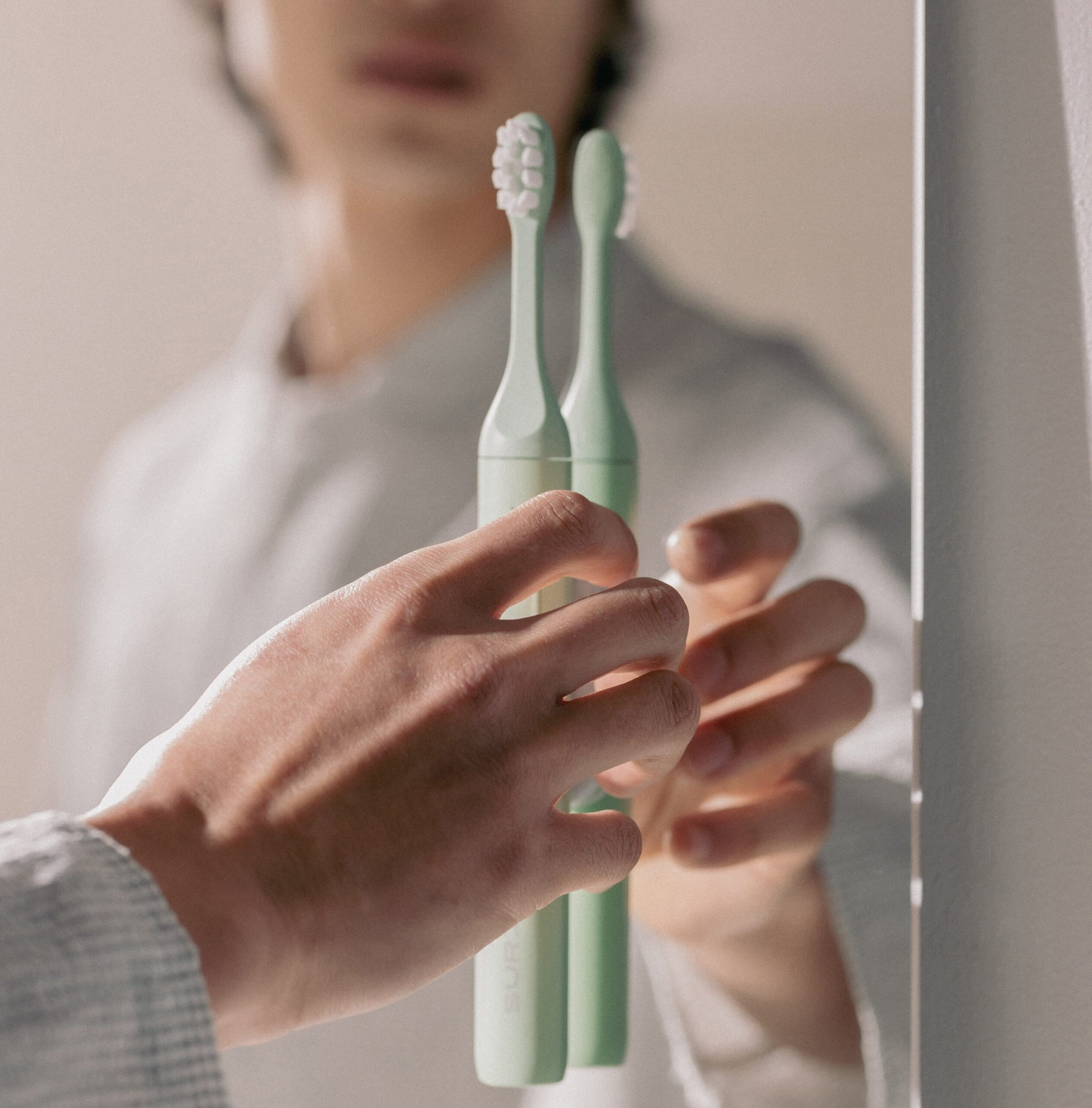 a model places their suri toothbrush onto the magnetic mirror mount.