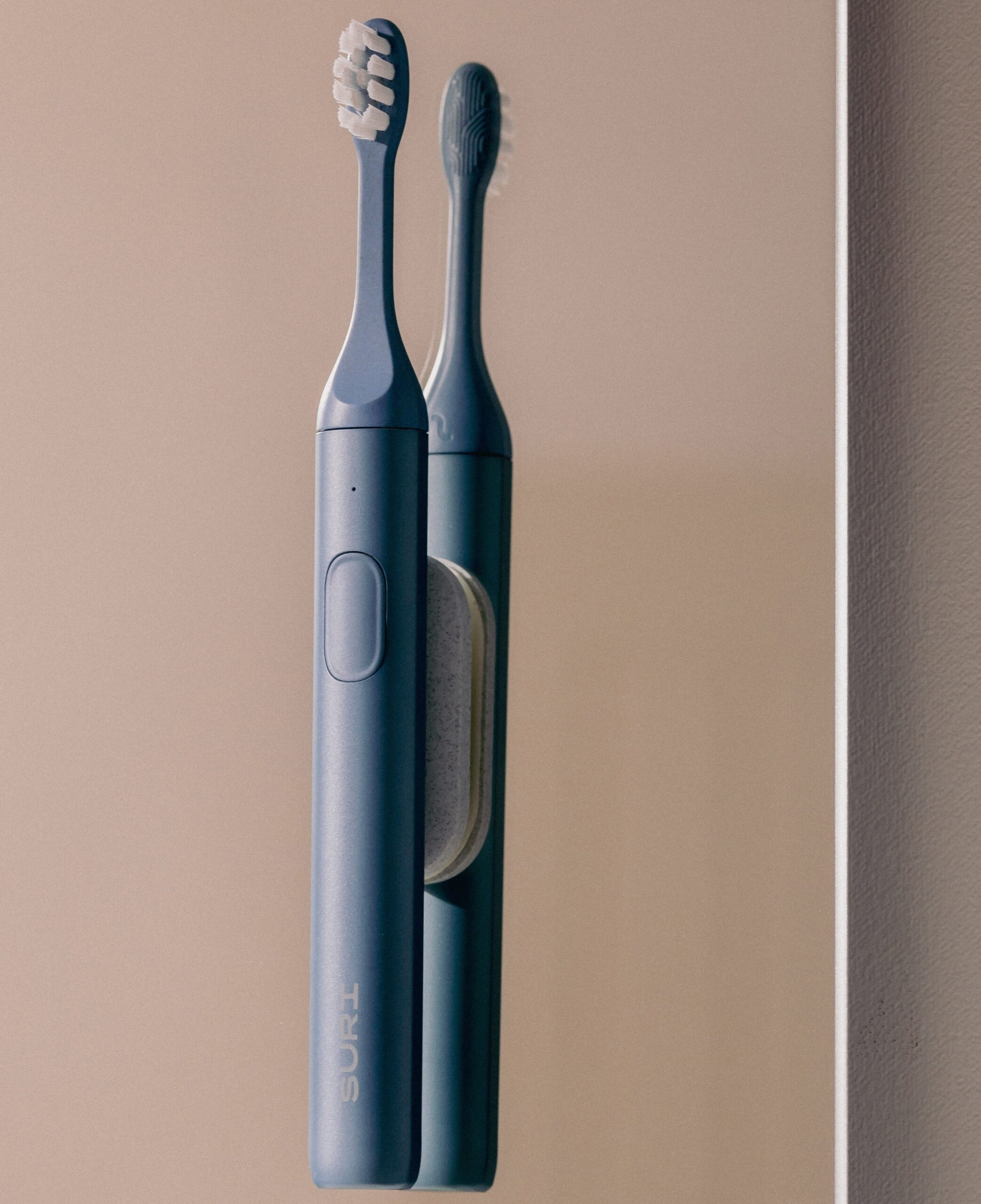 The SURI toothbrush connected to its magnetic mirror mount.