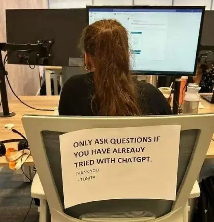 woman with sign that says only ask questions if you have already tried with chatgpt