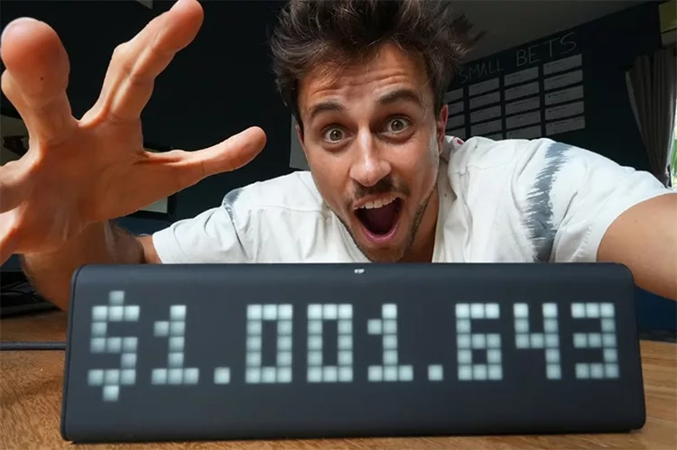 A person with a surprised expression is holding an electronic display showing the number $1,001,643.