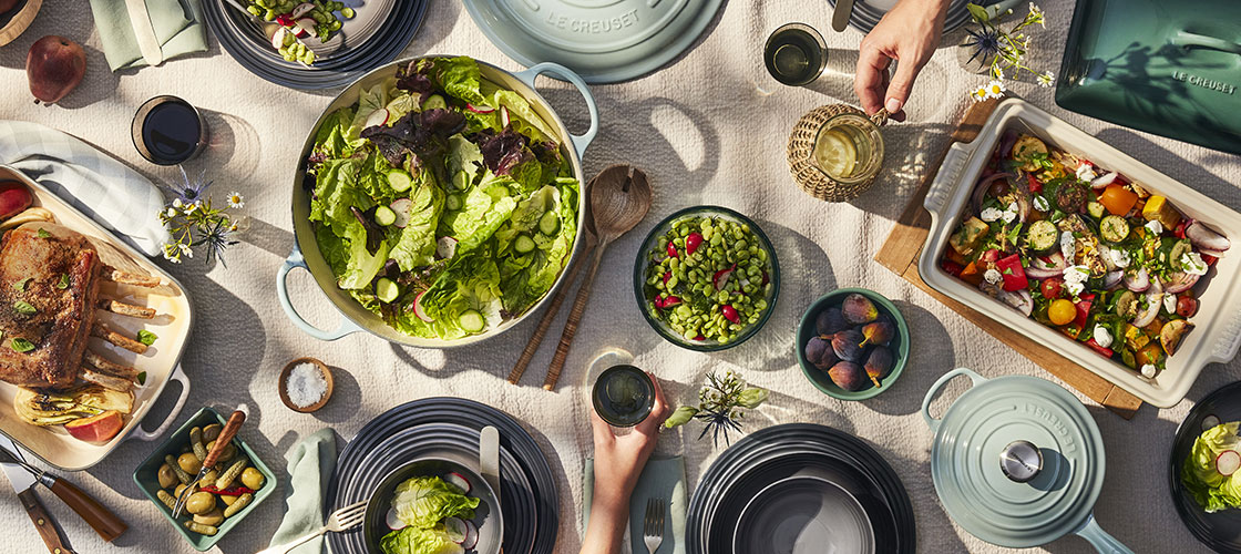 A large table covered with numerous plates of food, featuring a variety of appetizing dishes.