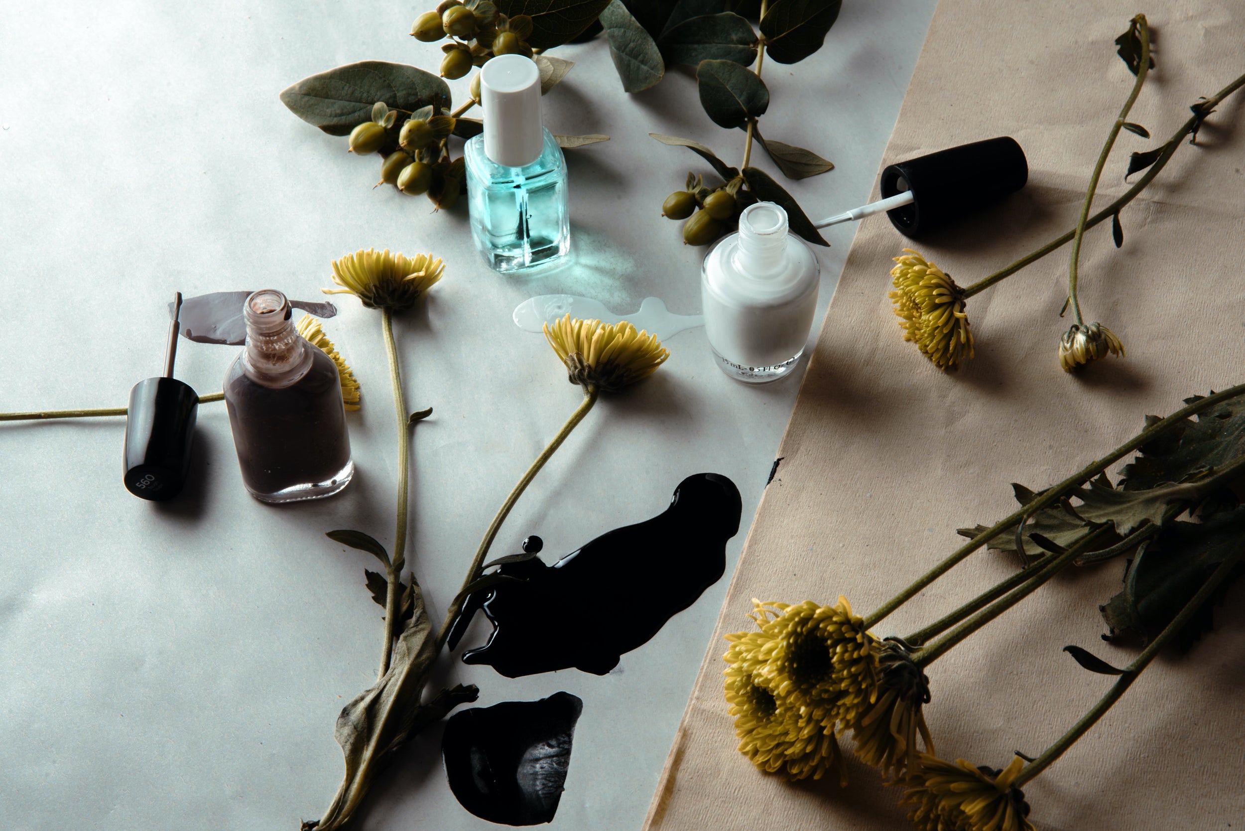 Nail polishes and flowers arranged on a table