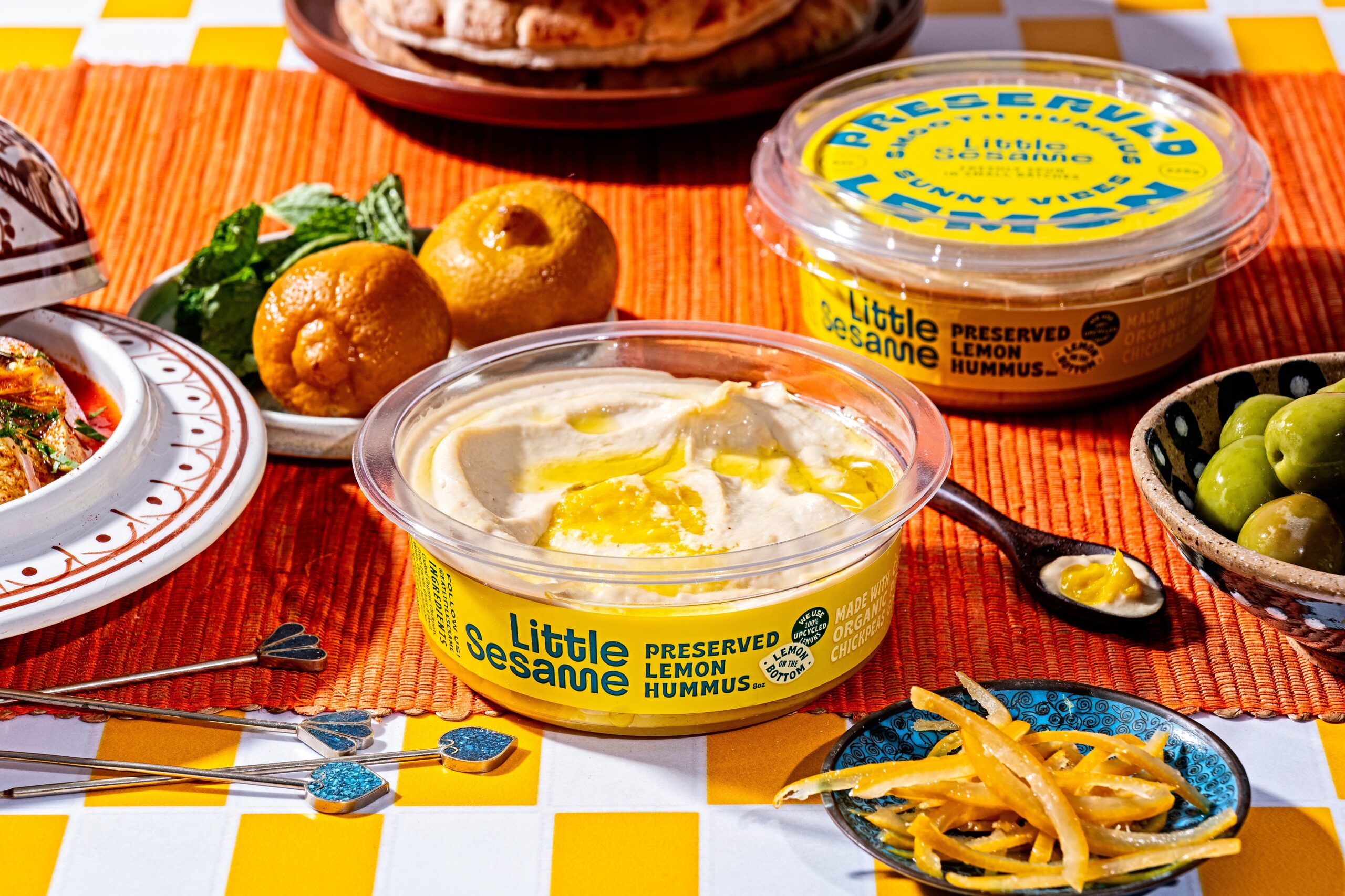 little sesame’s preserved lemon hummus on a table of food.