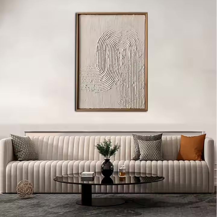 A textured abstract art piece hangs above a gray couch