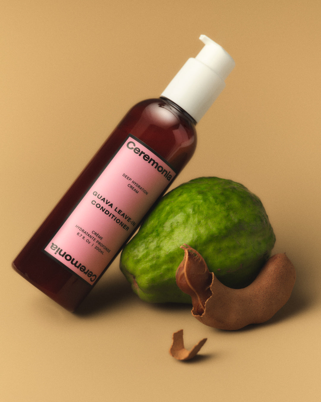 ceremonia’s guava leave in conditioner leaning on a guava.