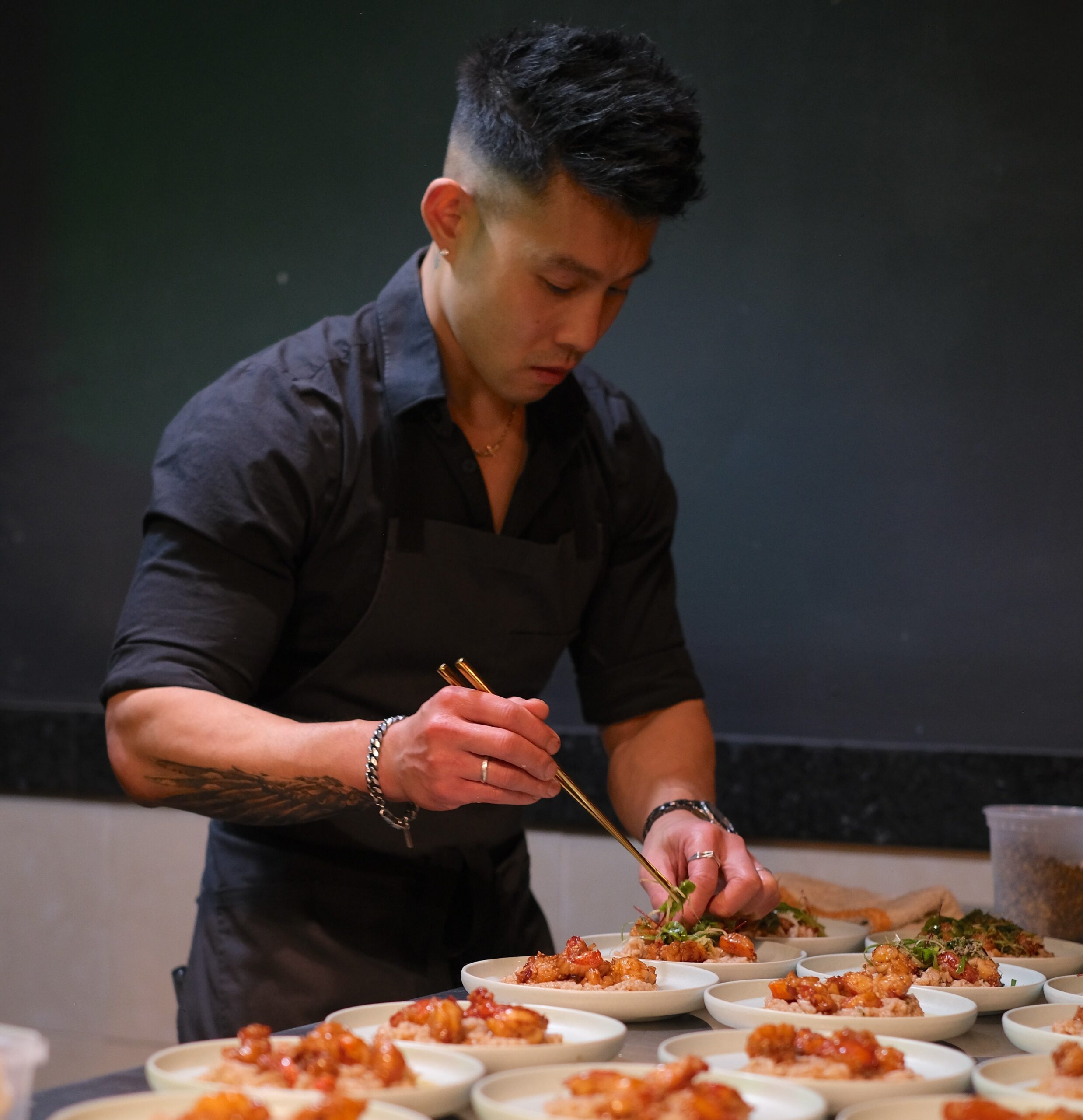 Wallace Wong places the green garnish on top of his dishes.