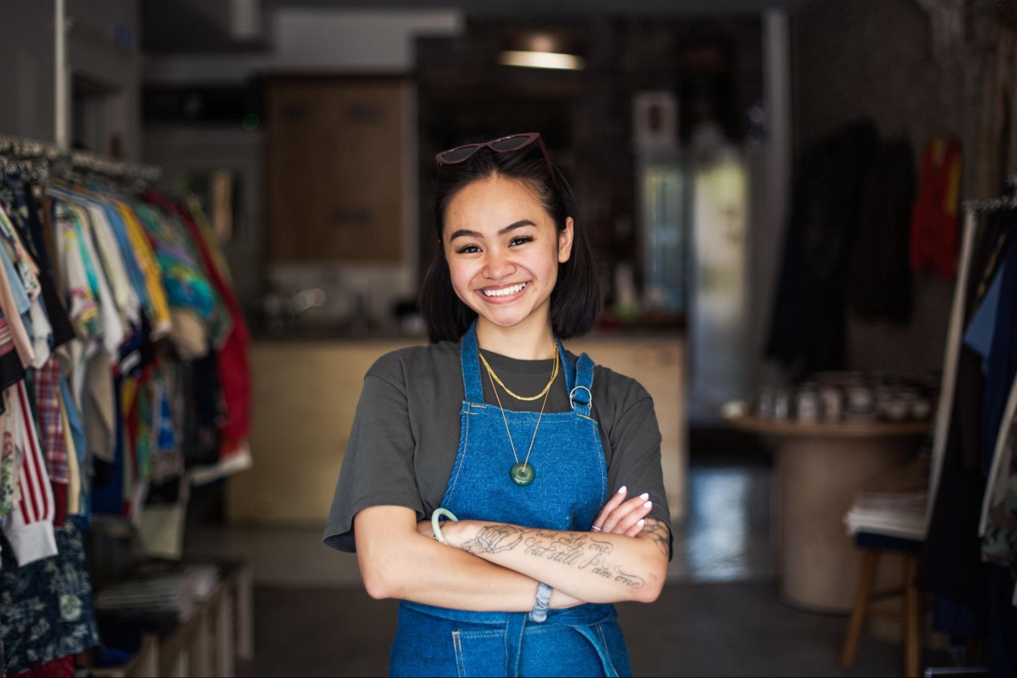 A local clothing store owner stands proud at the front of her retail store.