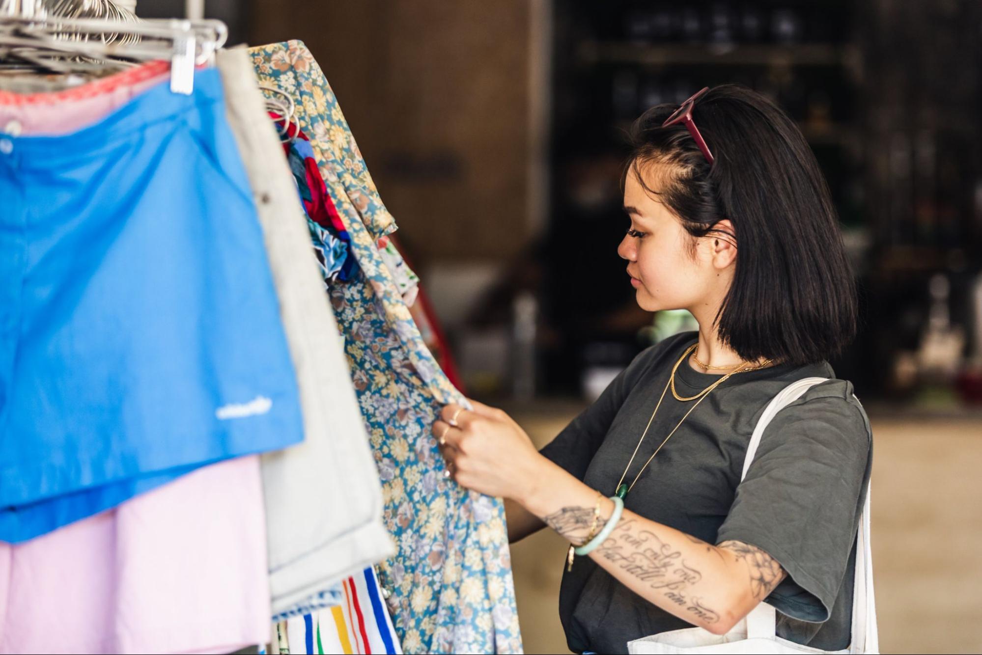 A woman browses the merchandise in a local clothing retail store as something catches her eye.