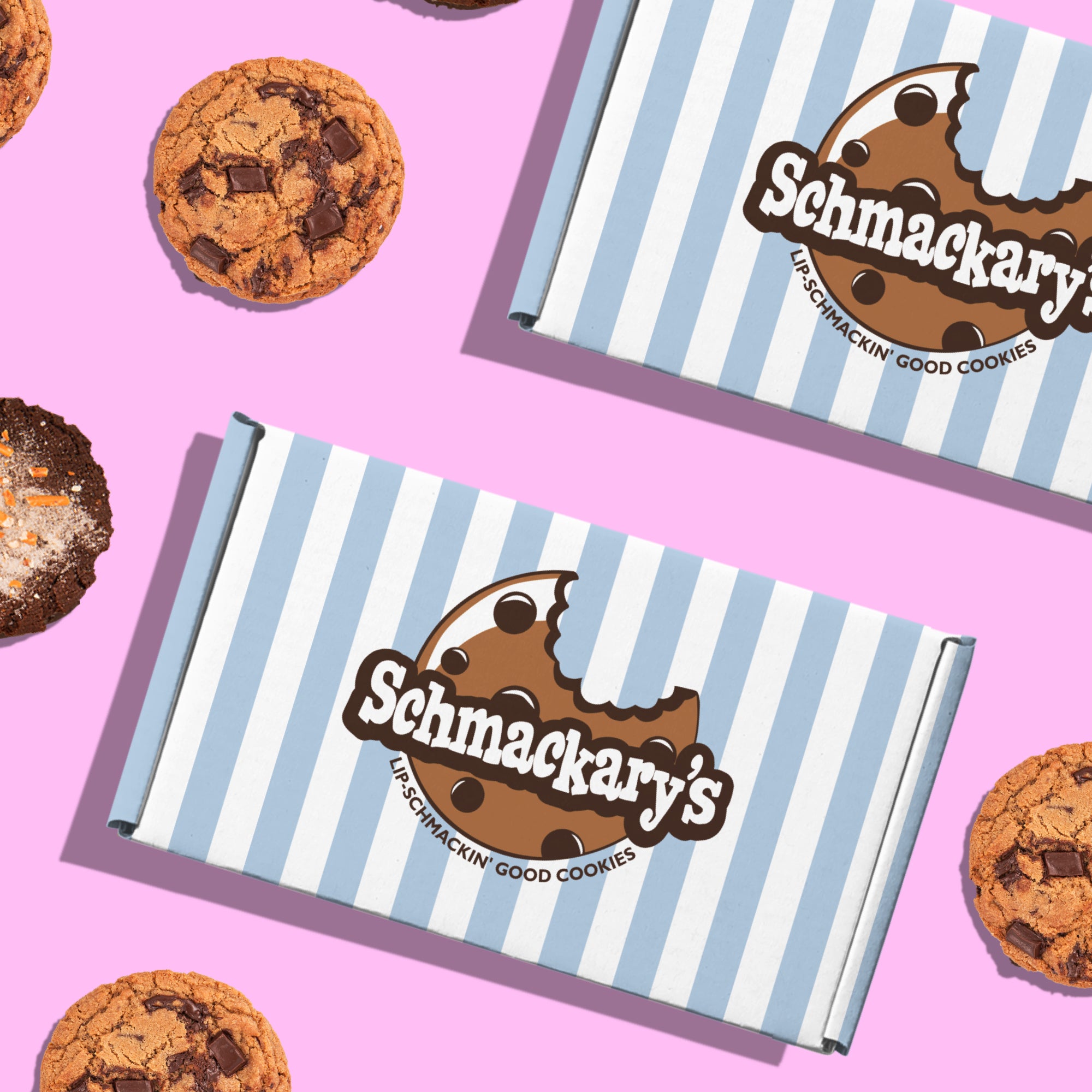 Schmackary’s cookies surrounded by their custom blue-and-white striped packaging box.