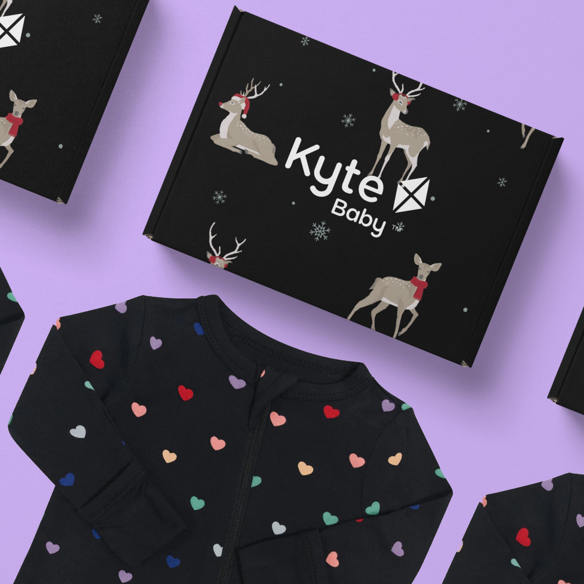 An Arka custom box for Kyte Baby laying next to a black onesie with colorful hearts on it.