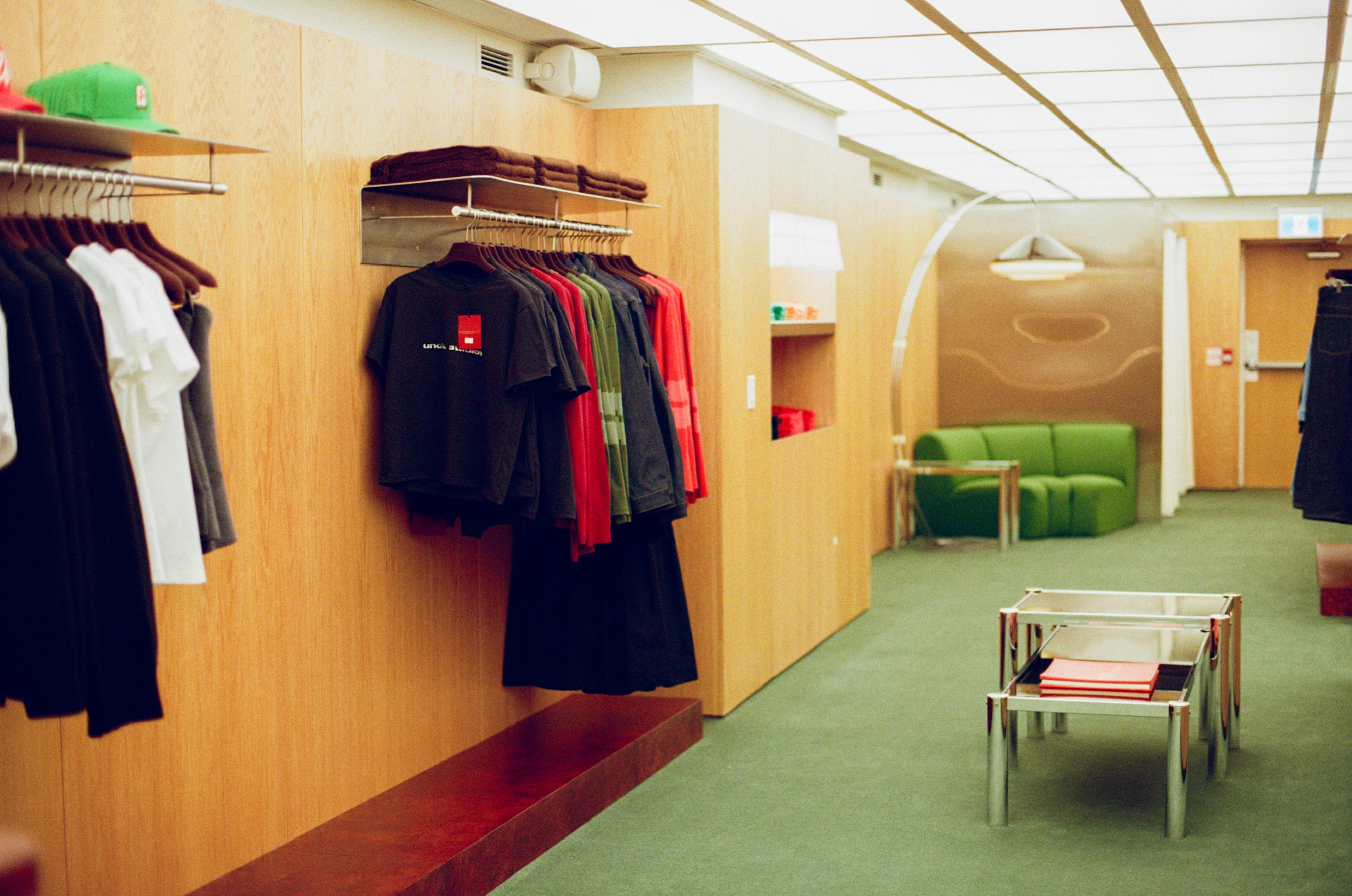 Interior of Uncle Studios store with clothing racks on the wall and a green couch in the corner.