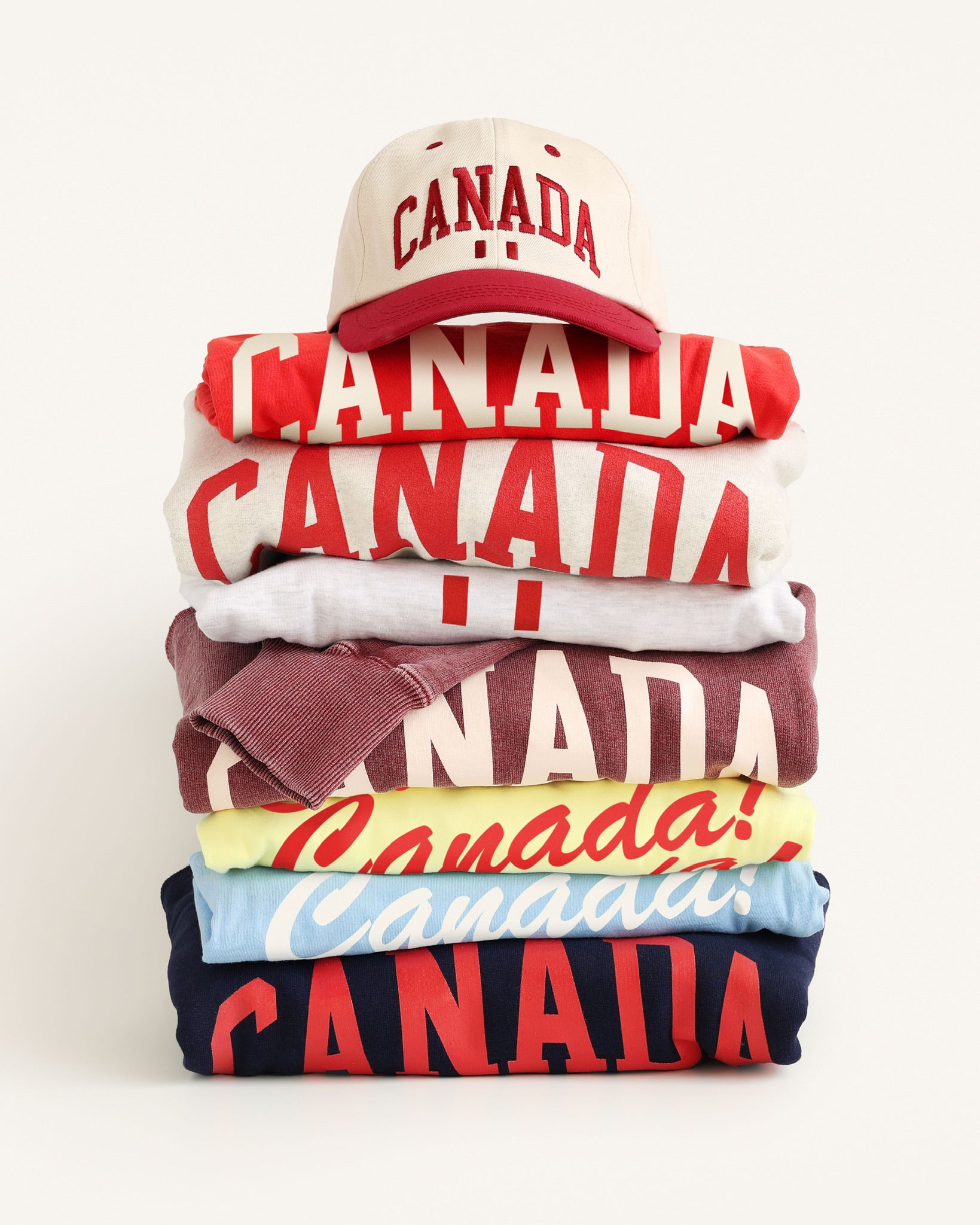 Province of Canada hoodies stacked up with a Province of Canada hat sitting on top.