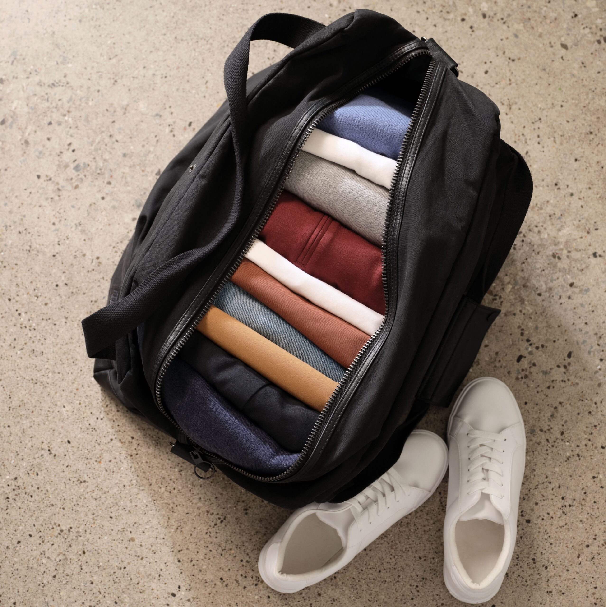 Unbound Merino t shirts folded up and packed nicely into a duffle bag for travel.